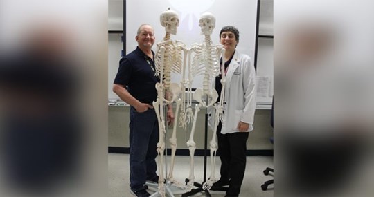 Teachers standing with plastic skeletons